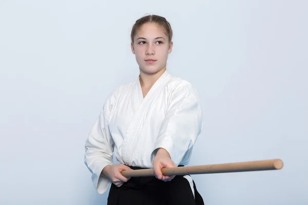 A girl in black hakama standing in fighting pose with wooden jo stick — Stock Photo, Image