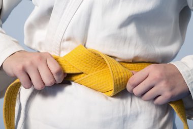 Bir genç üzerinde sarı kemer sıkma eller kimono giymiş