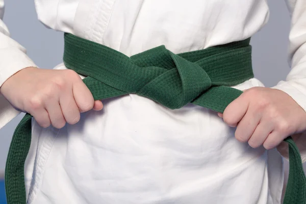 Ręce zaostrzenie zielony pas na nastoletniego ubrany w kimono — Zdjęcie stockowe
