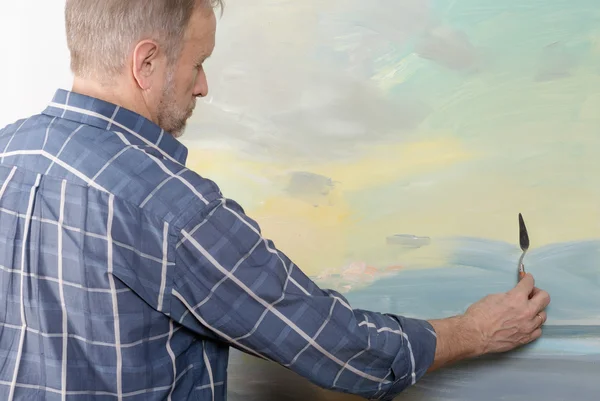 An artist painting with a palette knife in studio — Stock Photo, Image