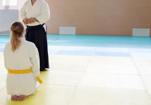 Sensei in kimono and hakama explaining the nuances of martial arts to a girl sitting on tatami — Stock Photo, Image