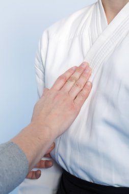 Dövüş sanatları için bir üniforma ile bir çocuk yardımcı olan ebeveyn eller