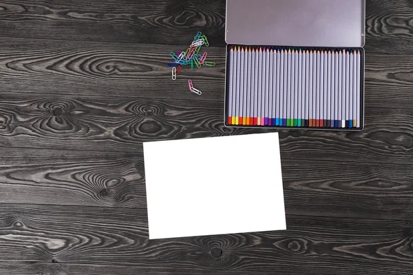Sheet of paper with a pencil on the old dark table. — Stock Photo, Image