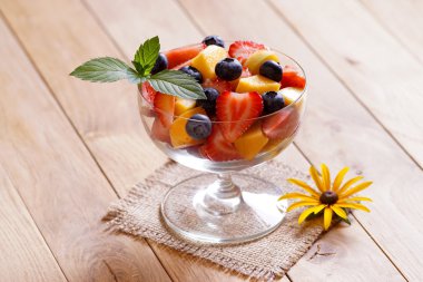 Çilek kayısı ve yaban mersini salatası. Kahverengi zemin.