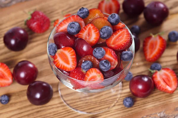 Salade met aardbeien pruimen en bosbessen. Bovenaanzicht. — Stockfoto