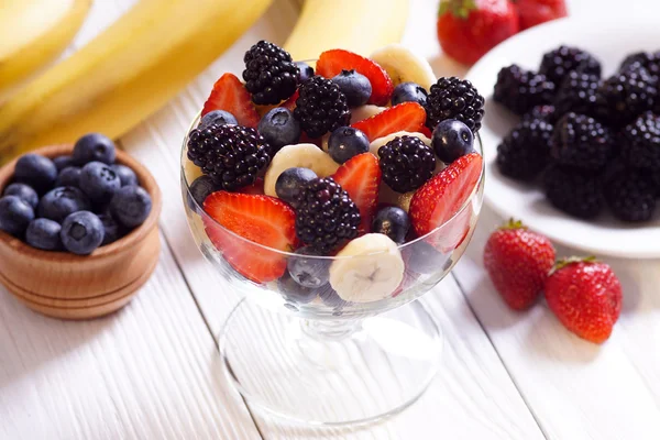 Salade aardbei banaan bosbessen en braambessen op witte boards. — Stockfoto