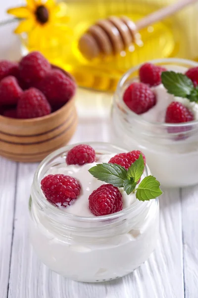 Yoghurt met frambozen op een witte tafel. — Stockfoto