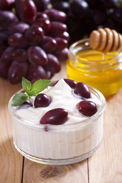 Yoghurt met druiven op de tafel. — Stockfoto