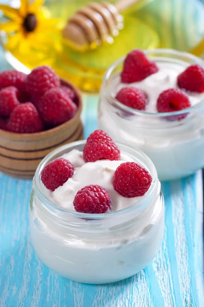 Yoghurt met frambozen in een pot op tafel. — Stockfoto