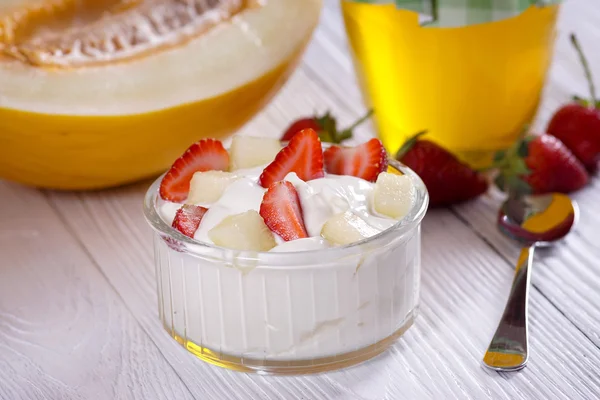 Bulgaarse yoghurt met aardbeien en melonon de tabel. — Stockfoto