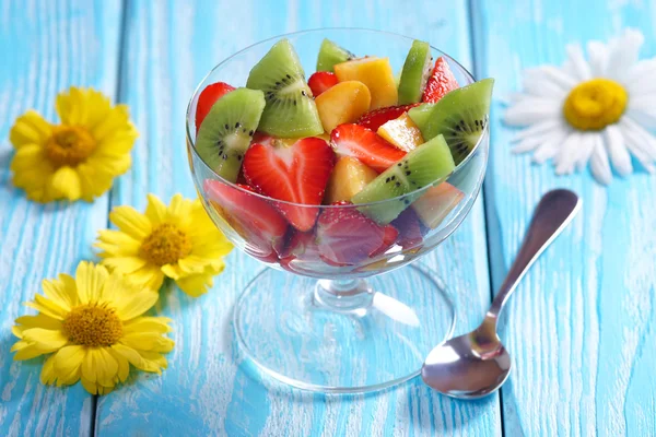 Salade met aardbei-kiwi en abrikozen. Blauwe achtergrond. — Stockfoto