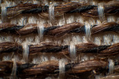 Sandalyeler için sentetik kumaş lifleri, iplikler arasında boşluklar olan kalın kumaşlar. Büyük beyaz-kahverengi lifler, yüksek büyütme, süper makro.