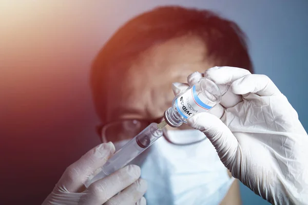 一个戴医疗手套的男人的手在模糊的背景下 在Covid 19疫苗瓶中植入了一个环 — 图库照片