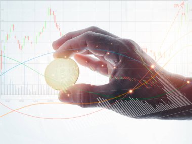 Bir adamın sağ eli baş parmağı ve işaret parmağıyla altın bir 