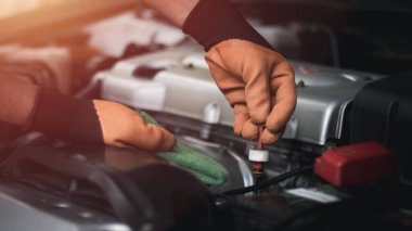 Otomobil tamircisi garajda çalışıyor. Tamir servisi. Motor yağı seviyesini kontrol et..