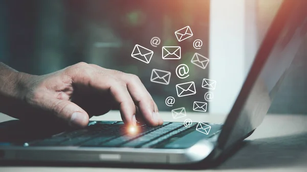 E- posta simgesi, e- posta konsepti içeren dizüstü bilgisayar kullanan bir adam eli