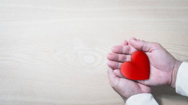 El ele tutuşan kırmızı kalp, sağlık, aşk, organ bağışı, farkındalık, refah, aile sigortası ve CSR konsepti, dünya kalp günü, dünya sağlık günü, Ulusal Organ Bağış Günü, dua konsepti