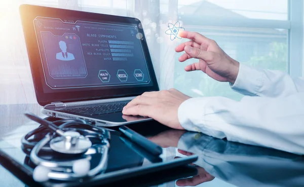 The doctor working on a laptop computer for health records in the medical office.The concept is checking and taking care of patients' health online.