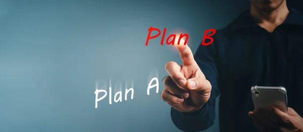 İş planı değişti. B planına işaret eden adam. Konsept bir gelişme, modernleşme. Esneklik ve yeni koşullara iş adaptasyonu. Eski yaklaşımları yeniden düşünmek.