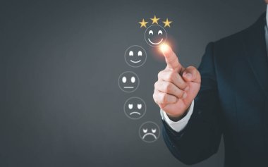 Bir adam işaret etmek için parmağını kullanır ve sanal ekranda göstermek için bir gülümseme ifadesi seçer. Kullanıcı deneyimi veya müşteri memnuniyeti araştırması anketi, anket veya anket. Konsept 