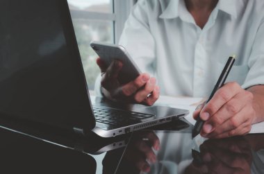 Konsept evden çalışmak. Dizüstü bilgisayarla, dijital tabletle ve ev ofisinden cep telefonu kullanarak birden fazla iş adamı çalıştırmak.