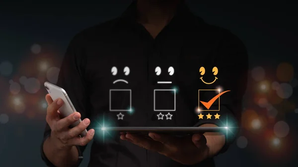 İş adamı gülümsemeli bir tablet bilgisayar ve müşteri hizmetleri için en iyi iş derecelendirme deneyimi için 3 yıldız simgesi tutuyor. Memnuniyet araştırma konsepti.