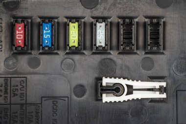 Otomotiv, devrelerde izlenen akım aşıldığında elektriksel devreyi açan koruyucu bir cihaz olan siyah paneldeki tutucular ve çok renkli işaretlerle birleşir. Elektrik Tamiri.