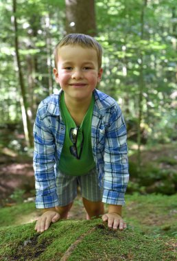 Ormanda yürüyen sevimli küçük çocuk. Turist yürüyüşü.