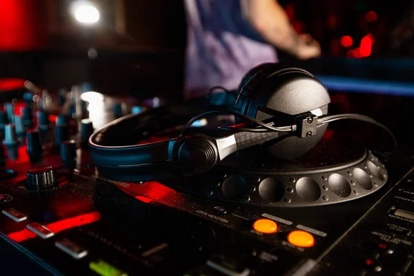 DJ tem pausa na sessão de música. Feche a foto do console de hóquei em disco ou toca-discos com fones de ouvido em cima dele. Equipamento de mistura. Conceito de vida clube. — Fotografia de Stock