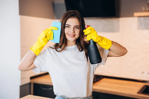 Retrato de hielo atractivo ama de casa juguetona usando aerosol que se divierte luchando contra el polvo de matar luchando en la casa de la cocina interior blanca luz moderna —  Fotos de Stock