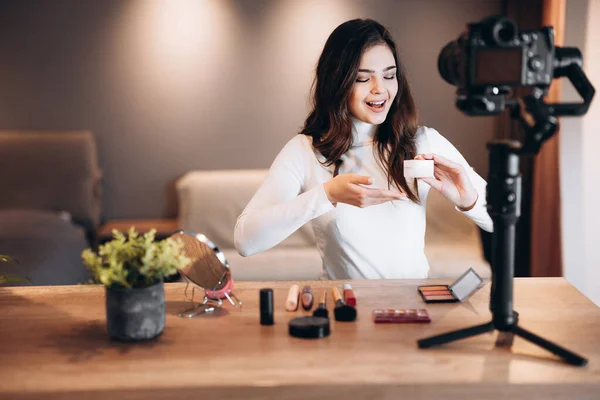 Güzellik blogcusu kadın günlük makyaj rutin dersini kamerayla çekiyor. Etkilenen tatlı kadın canlı yayın kozmetik ürünleri eleştirisi ev stüdyosunda. Vlog işi
