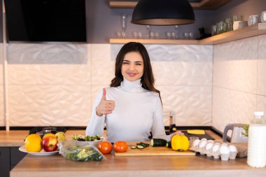 Genç bir kadın mutfağında sebze salatası hazırlıyor. Sağlıklı yaşam tarzı kavramı. Karışık sebzeli güzel bir kadın.