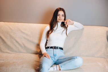 Hoş ve çekici genç kız evdeki kanepede oturuyor. Öğrenci. Serbest Çalışan.