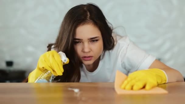 Wanita muda membersihkan di rumah. Model wanita berambut cokelat membersihkan permukaan memasak di dapur. Gadis itu membersihkan kotoran di apartemen. — Stok Video