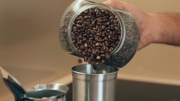 Großaufnahme von Kaffeebohnen in einer Dose werden in eine Kaffeemühle gegossen. Hausgemachter Kaffee am Morgen. Zeitlupenaufnahmen — Stockvideo
