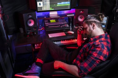 Müzik kayıt stüdyosunda çalışan ses mühendisinin fotoğrafı. Karıştırma tahtası kullanarak modern ses yaratıyor. Kontrol masasında başarılı bir müzisyen.