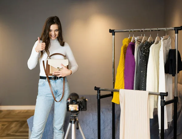 Blogger influencer girl con cabello oscuro está mostrando su ropa para sus seguidores en las redes sociales para venderla en línea. — Foto de Stock