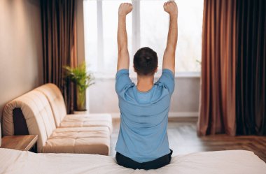 Günaydın genç adam. Yatakta uyanıyor ve kollarını geriyor, geriye bakıyor, boşluğu kopyalıyor.