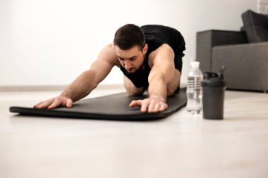 Spor kıyafetli bir adam çocuk Asana taklidi yapıyor, dinlenme seansını tamamlıyor, egzersiz yapıyor beden ve zihni sakinleştiriyor, dersten sonra yorgunluğu azaltıyor, sağlık konsepti. Evde yoga pratiği yapıyorum..