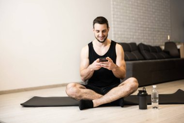 Zinde bir adam yoga minderinde bacak bacak üstüne atıp arkadaşlarıyla telefonla mesajlaşır. Dinlenme zamanı. Atletik adam evde antrenman yapmak için tembeldir ve internette komik mimler okur..