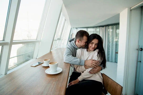 Feliz casal amoroso abraçando no café com carinho. Homem bonito e mulher atraente passar fim de semana no aconchegante café juntos. Conceito de data romântica. Início da história de amor. — Fotografia de Stock