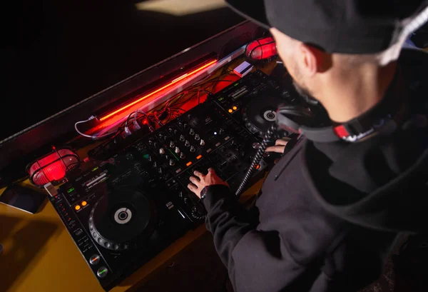 Ο DJ ανακατεύει τραγούδια σε νυχτερινό κέντρο διασκέδασης. Κάτοψη του disc jockey σε smart casual ρούχα παίζοντας μουσική σε πικάπ. Έννοια της νυχτερινής ζωής. Επαγγελματικός εξοπλισμός μουσικής. — Φωτογραφία Αρχείου