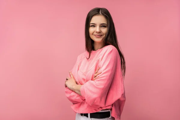 Çekici genç kadın gülümsemesinin fotoğrafı çapraz el kameraya bak günlük pembe tişört giy beyaz, izole edilmiş pembe arka plan