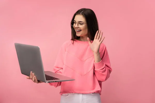 Фото привлекательной дамы в очках, имеющей онлайн встречу, держит ноутбук и работает в Интернете. носить случайные розовые футболки белые брюки изолированный розовый цвет фона. — стоковое фото