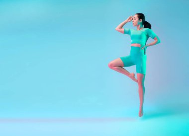 Zarif. Genç sportif kadın eğitimi neon ışıklarıyla izole edilmiş. Modern spor, aksiyon, hareket, gençlik konsepti. Güzel beyaz kadın pratik yapıyor.