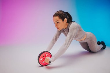 Genç, formda ve beyaz tenli kadın portresi. Arka planda baskı çarkı var. Yaz için mükemmel bir vücut. Güzellik, tatil köyü, spor konsepti