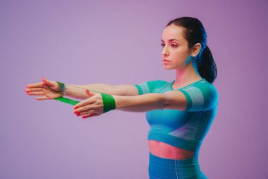 Genç, formda ve beyaz tenli, direniş bandı olan bir kadın. Formda sporcu kadın pozu. Yaz için mükemmel bir vücut. Güzellik, tatil köyü, spor konsepti.