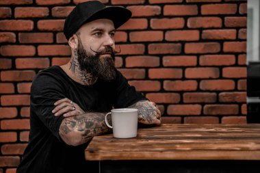 Sakallı genç erkek kahve içiyor. Hipster adam kahve molası veriyor. Yaşam tarzı insan konsepti.