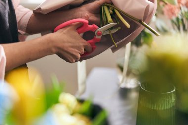 Çiçekçi, çiçekçide güzel bir buket hazırlıyor. Dalları kesme.