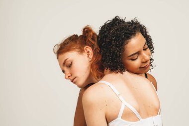 Photo of natural multiracial women, body positive. Feminist females in underwear hug and feel support, isolated on white background. Concept natural beauty and girl power